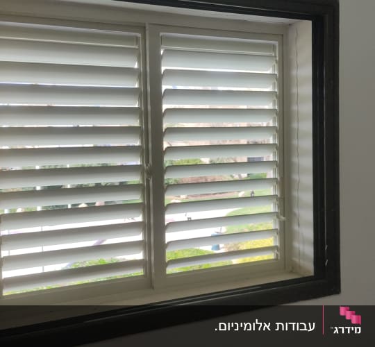 חלון עם תריסי אלומיניום לבנים